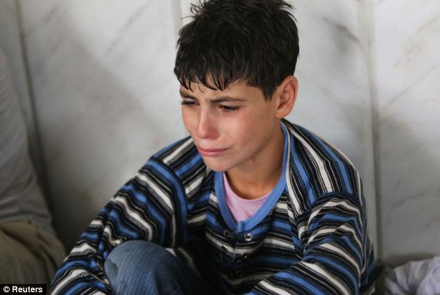 A young survivor of the alleged gas attack cries as he takes shelter inside a mosque 
