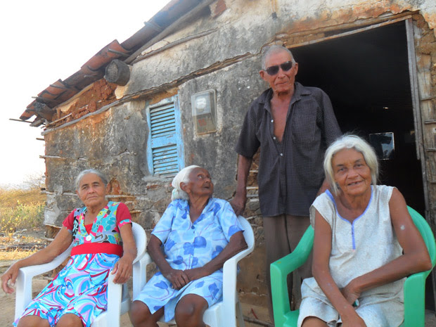 Luiz Costa de Oliveira, 90 anos, com as três mulheres, na frente de casa, em Campo Grande (Foto: Júnior Liberato/Arquivo Pessoal)