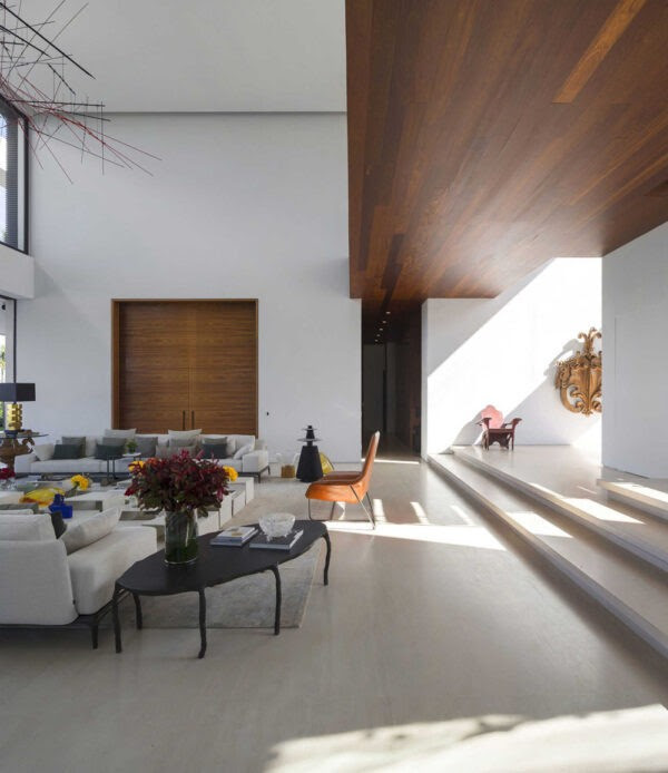 Warm woods blend together with pops of color and sleek neutrals, making this living area feel lively but still serene. After all, this is a family home.