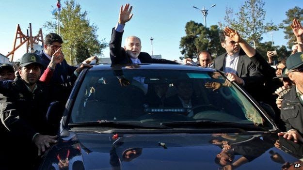 Iranian Foreign Minister Mohammad Javad Zarif, who is also Iran"s top nuclear negotiator, waves to his well wishers upon arrival at the Mehrabad airport in Tehran, Iran