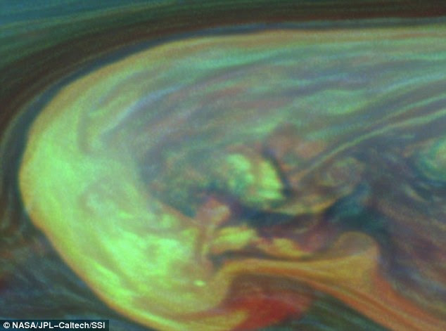 This false-colour image from the Cassini spacecraft reveal one of these superstorms in detail. Clouds that appear blue here are the highest and are semitransparent. Those that are yellow and white are thick clouds at high altitudes. Those shown green are intermediate clouds. Red and brown colors are clouds at low altitude