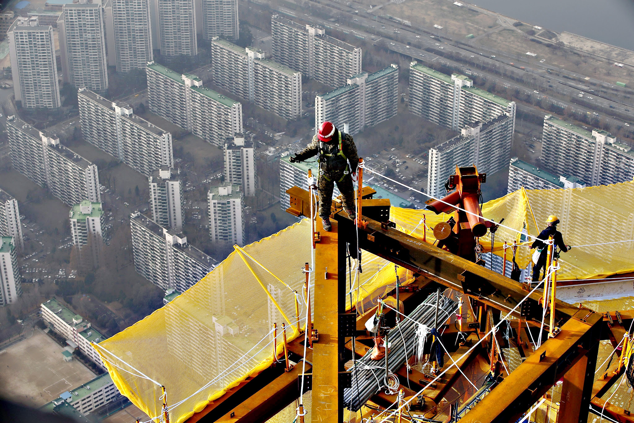 South Korean workers are seen from a crane as they work on the 123rd floor during the framing completion ceremony of the 'Lotte World Tower' in Seoul, South Kora, on Tuesday. The building's exterior was completed in a final height of 550 meters, and 123 floors