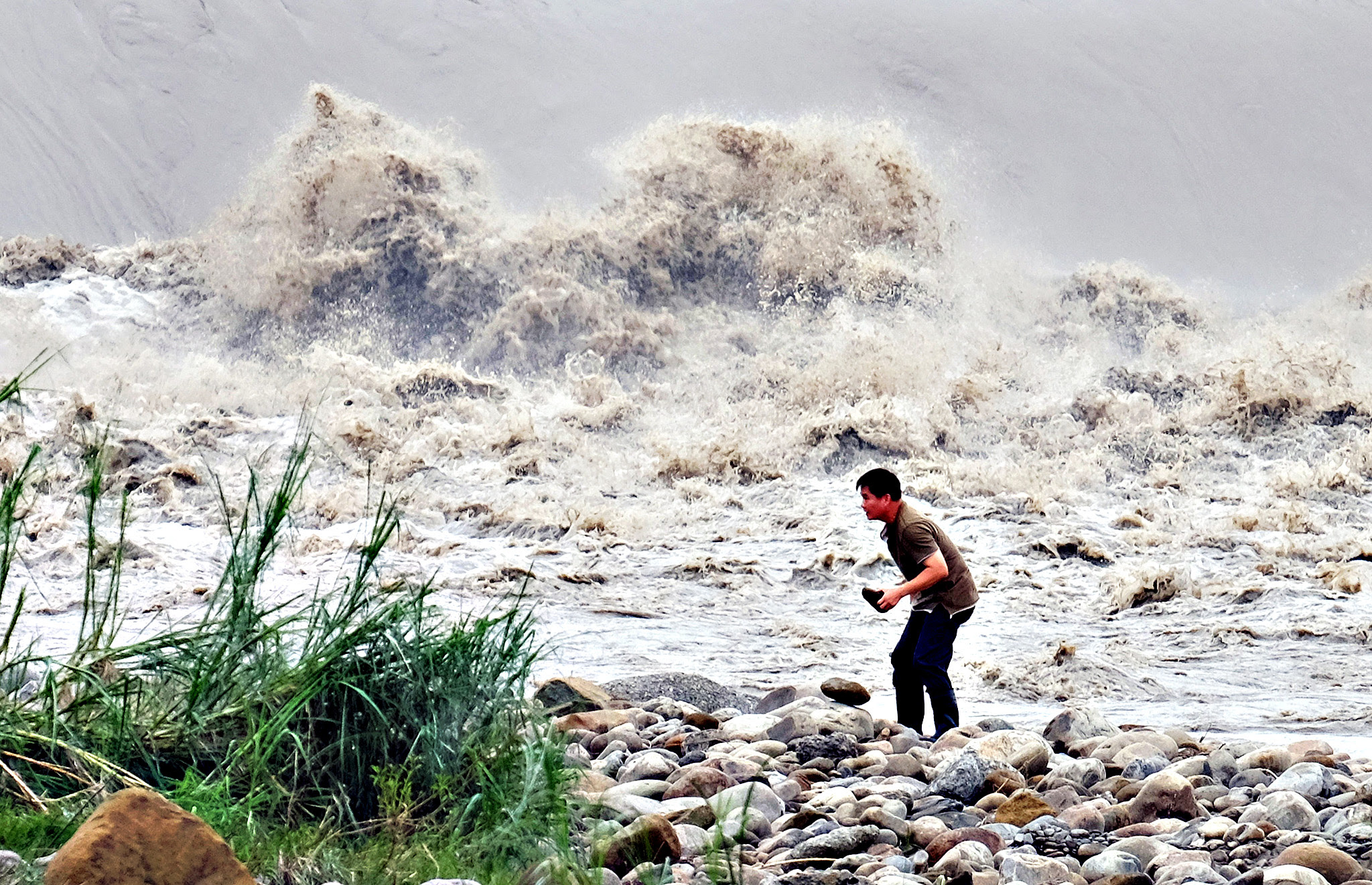 A local resident collects stones from the Xindian river after Typhoon Dujuan passed in the New Taipei City on September 29, 2015. Super typhoon Dujuan killed two and left more than 300 injured in Taiwan before making landfall in China.