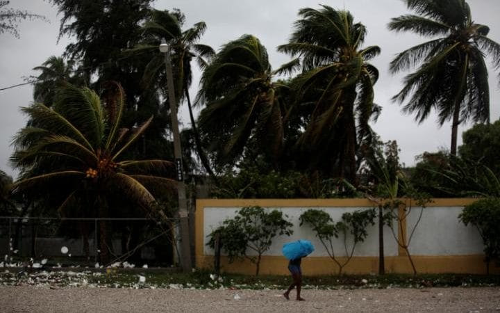 A woman protects herself from rain with an umbrella ahead of Hurricane Matthew in Les Cayes, Haiti