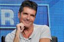 FILE - This Aug. 1, 2013 file photo shows Simon Cowell, a judge on the "The X Factor," smiles from the stage during a panel discussion on the show at the FOX 2013 Summer TCA press tour in Beverly Hills, Calif. The British edition of "The X Factor" is coming to U.S. television. Music entertainment cable channel AXS TV said Wednesday, Aug. 6, 2014, it will begin airing the singing contest's 11th season on Labor Day weekend. "X Factor" creator Simon Cowell is on the judging panel, which includes ex-Spice Girl Mel B and pop singer Cheryl Fernandez-Versini, formerly known as Cheryl Cole. (Photo by Chris Pizzello/Invision/AP, File)