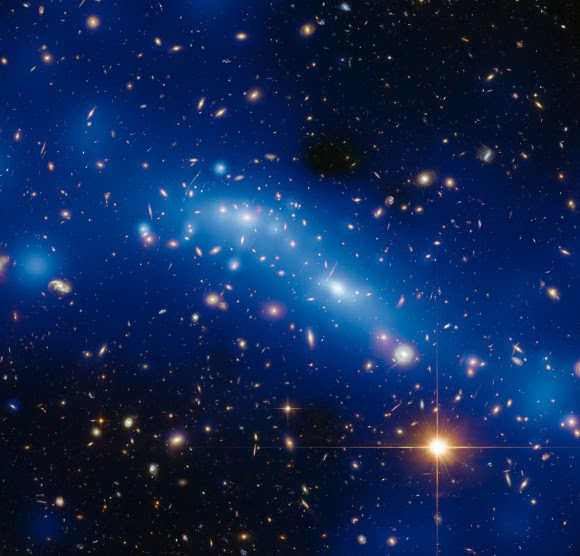 This image shows the galaxy MCS J0416.1–2403, one of six clusters targeted by the Hubble Frontier Fields programme. The blue in this image is a mass map created by using new Hubble observations combined with the magnifying power of a process known as gravitational lensing. In red is the hot gas detected by NASA’s Chandra X-Ray Observatory and shows the location of the gas, dust and stars in the cluster. The matter shown in blue that is separate from the red areas detected by Chandra consists of what is known as dark matter, and which can only be detected directly by gravitational lensing.Credit: ESA/Hubble, NASA, HST Frontier Fields. Acknowledgement: Mathilde Jauzac (Durham University, UK) and Jean-Paul Kneib (École Polytechnique Fédérale de Lausanne, Switzerland).