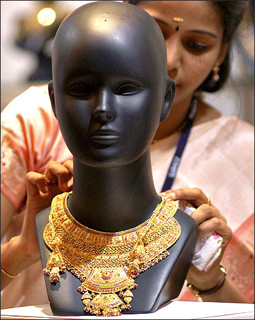 A worker arranges jewellery on a mannequin at a stall in Chennai.