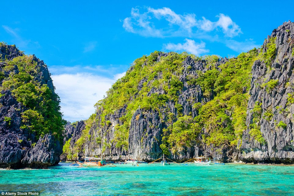 Tourist boats explore the Big Lagoon on Miniloc Island. The island has pristine white sands and a marine sanctuary teeming with wildlife
