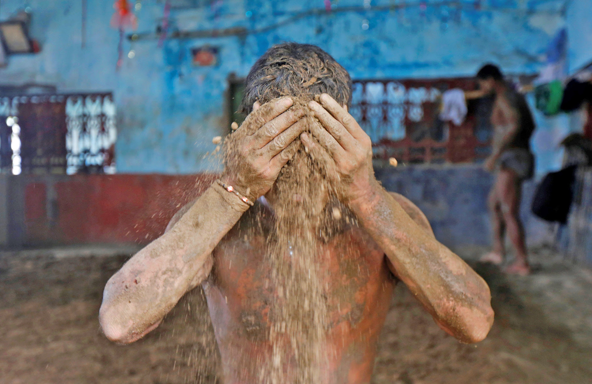 A wrestler applies mud to prevent slipping due to sweat, at a traditional training centre on the banks of the river Ganges ahead of the Bengal mud wrestling championships, in Kolkata, India today