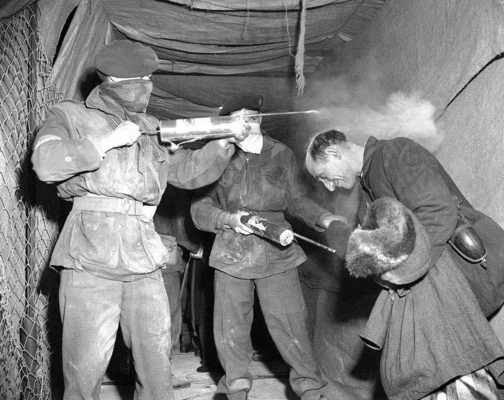 A Jewish refugee bows low on Feb. 16, 1947, as he receives a charge of DDT disinfectant from soldiers of the British 6th Airborne Division before leaving Jerusalem on the Cyprus-bound ship, Ocean Vigour. (AP Photo/J. Walter Green) Ref #: PA.12465873 Date: 16/02/1947