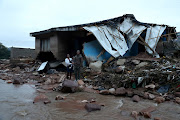 Siblings Phumlile Msomi, 30, Njabulo Msomi, 23, and Khanyisa Msomi,11 months, in front of their destroyed home in Ekukhanyeni in Pinetown. 