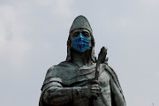 The monument of Tezozomoc wears a mask that reads ‘For My Country’ in Mexico City. 