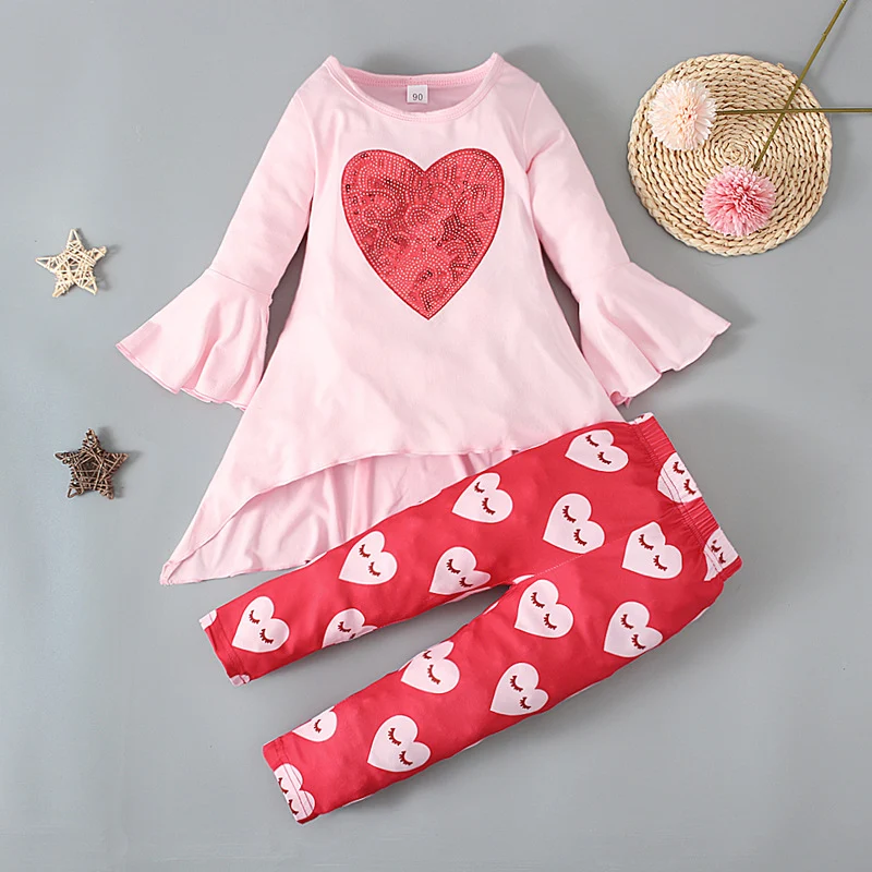 Conjunto de duas peças com top de manga flare e calças com estampa de amor. Look estiloso e romântico para diversas ocasiões.
