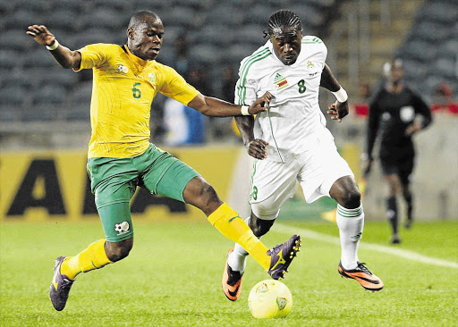 Hlompho Kekana of Bafana Bafana tries to stop speedster Kingston Nkhatha of Zimbabwe during the friendly international match between the two countries at Orlando stadium, Soweto, last night. The visitors won 2-1