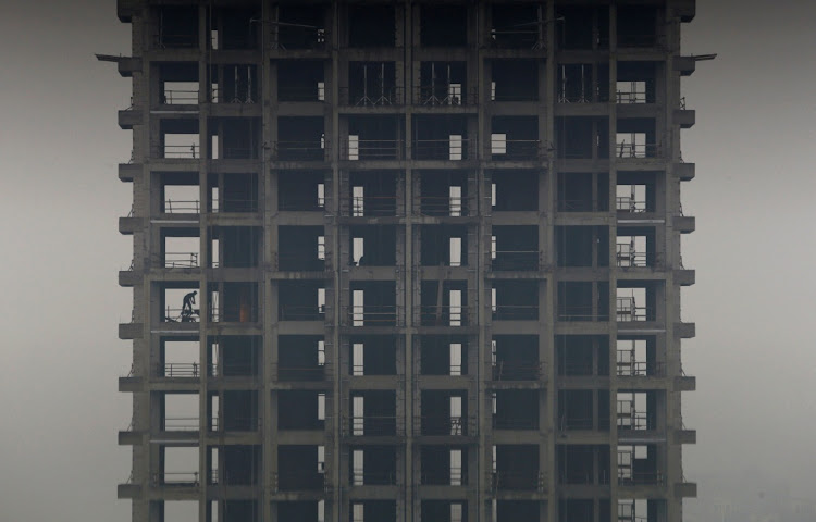 A labourer works on a construction site of a residential building during a hazy day in Hangzhou, Zhejiang province. Picture: WILLIAM HONG