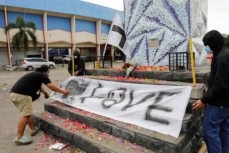 Arema football club supporters, known as Aremania, put a banner on a monument outside the Kanjuruhan stadium to pay condolence to the victims, after a riot and stampede following soccer match between Arema vs Persebaya outside in Malang, East Java province, Indonesia, October 2, 2022.