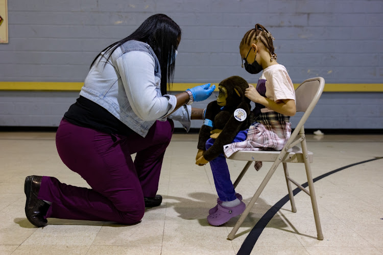 A healthcare worker pretends to administer a dose of the Pfizer-BioNTech Covid-19 vaccine to a child's stuffed animal at a Salvation Army vaccination clinic in Philadelphia, Pennsylvania, on Friday November 12.