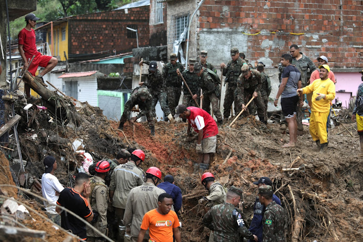 Firefighters, volunteers and soldiers work at a site where a house collapsed during heavy rain and flooding, in Recife, Brazil, May 29 2022. Picture: DIEGO NIGRO/REUTERS