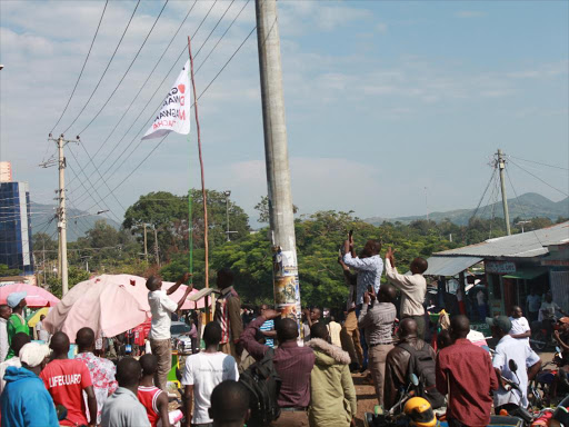 Kasipul MP Oyugi Magwanga’s supporters hoist a flag bearing the governor aspirant’s image and nickname in Homa Bay Town yesterday / ROBERT OMOLLO