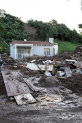 .The path of destruction can be clearly seen behind this house that was struck by a wall of mud and debris in the early hours of Tuesday, claiming the lives of a six-year old boy and a 21-year old. The families of the two were to distraught to speak to media. 