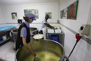 Rachel Belcher and Lameck Theu make cheese at the Belnori Cheese Farm.