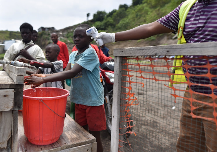 A health worker checks the temperature of a Congolese child amid the Covid-19 coronavirus outbreak in Goma, eastern Democratic Republic of Congo, March 19, 2020.