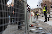 Security guards stand by the temporary fencing around the perimeter of Trafalgar Square, to prevent crowds gathering on New Year's Eve, in London, UK, on December 31 2021. 