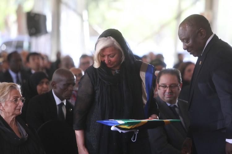 Former foreign affairs deputy minister Aziz Pahad’s wife Angina receives from President Cyril Ramaphosa a South African flag that was draped over his coffin.