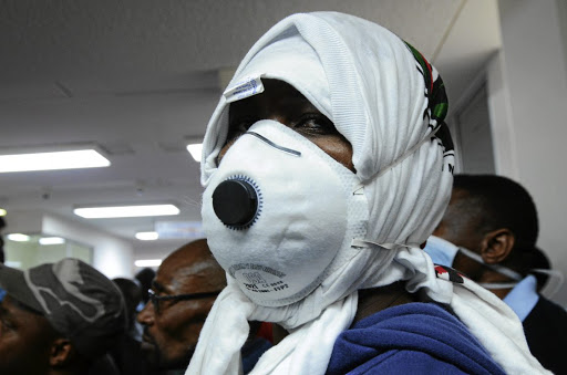 Charlotte Maxeke hospital worker hide behind a surgical mask during protest over unpaid bonuses.