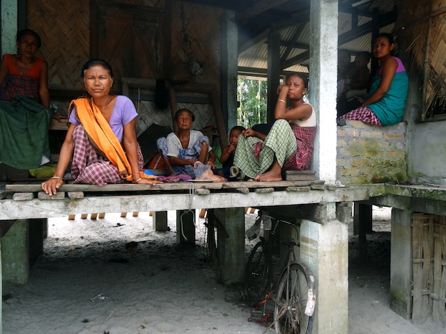 Women from the Mishing community in Dhemaji district are shocked by the siltation caused by the floods. Their homes on stilts – known as chaang ghor – are built on a raised platform. But the sands have submerged the homes in this village by two feet. Credit: Priyanka Borpujari/IPS