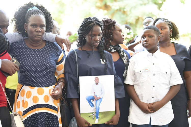 Radio Africa Group reporter Dickens Wasonga's daughter Kate Ochieng and Victor Ochieng during a requiem mass at St. Stephen's Cathedral ACK in Milimani, Kisumu on Thursday.