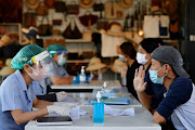 Migrant workers talk with the public health authorities for a Covid-19 investigation at a fresh market, amid the coronavirus disease (Covid-19) outbreak, in Bangkok, Thailand, December 22, 2020. 