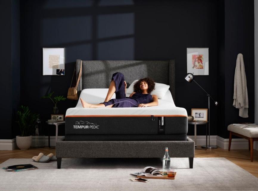 a woman laying on an adjustable base bed