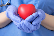 Doctor holding a red heart shape.