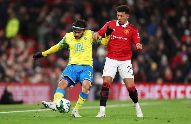 Gustavo Scarpa of Nottingham Forest is challenged by Jadon Sancho of Manchester United during the Carabao Cup semifinal, second leg match at Old Trafford on February 1, 2023 in Manchester