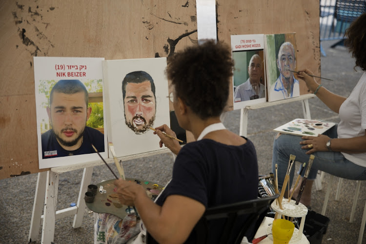 Artists paint portraits of hostages kidnapped during the Hamas attack on the Israeli south in Tel Avis on October 26, 2023. Picture: Amir Levy/Getty Images