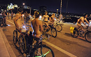 Michael Rutledge (L) and Sarah Lynch pause to watch and applaud as Portland bikers ride in celebration of the annual World Naked Bike Ride in Portland, Oregon June 18, 2011. World Naked Bike Ride is a globally observed event among hard-core bikers designed, at least ostensibly, to promote the use of the bicycle for transportation. But Portland cyclists have been especially adamant about making it another of the Pacific Northwest city's quirky traditions. Picture taken June 18, 2011.  REUTERS/Greg Wahl-Stephens