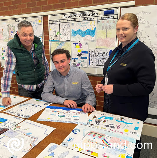 East Gippsland Water staff Judd Boeker, Adam Hudson and Colleen Roach inspect some of the hundreds of entries to the National Water Week poster competition