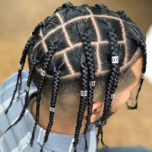 a guy showing off his box braids with silver cuffs