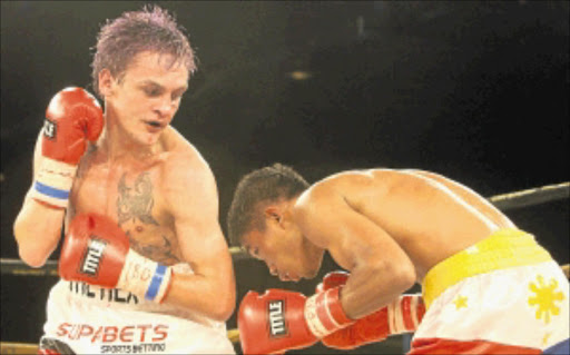 ROOM SERVICE: Hekkie Butler, left, serves Flipino challenger Michael Landero a fistful to win a strawweight title on Saturday. Photo: SYDNEY SESHIBEDI