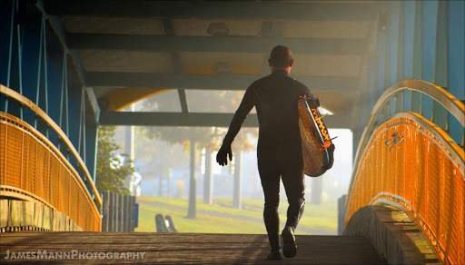 A young man walks over a little covered bridge in New Brunswick, Canada, just before the tide arrives from the Bay of Fundy.