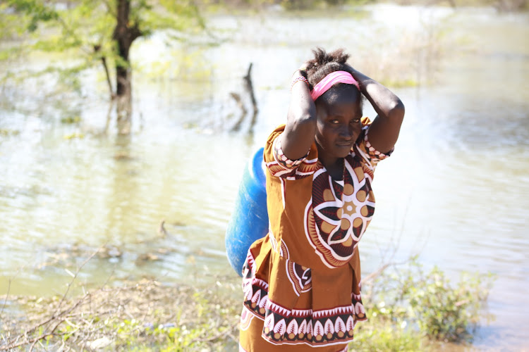 Lake Baringo flood victim Emily Cheburet carrying water she fetched at Loruk shore on November 15, 2020.