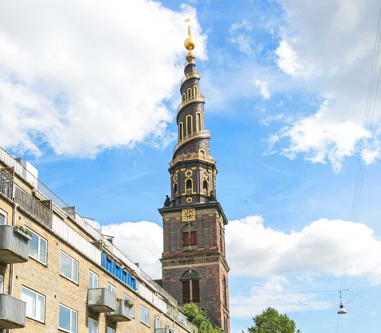   A church spire rises above the Christianshavn neighborhood in Copenhagen. 