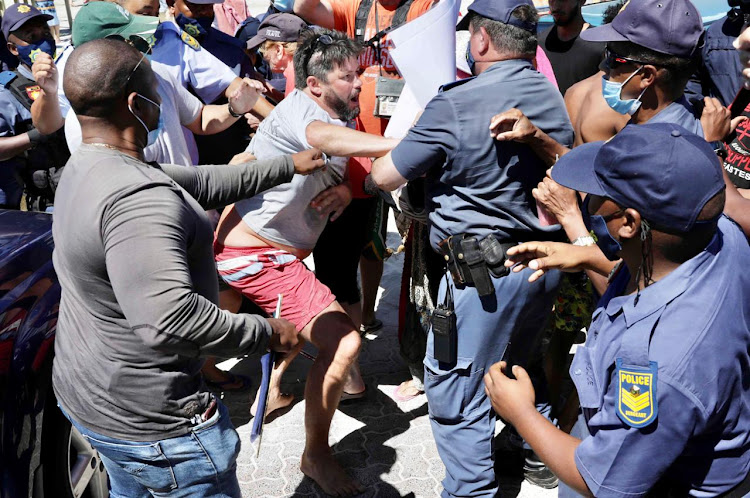 Police arrest an anti-Covid-19 lockdown protester after assault on journalist at Fish Hoek Beach in Cape Town at the weekend.