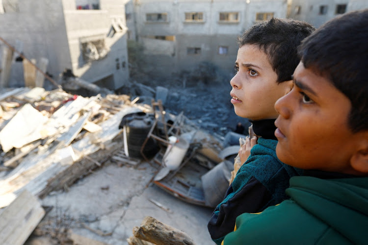 Palestinian children look at the damage at the site of Israeli strikes on houses in Khan Younis in the southern Gaza Strip, December 10 2023. Picture: IBRAHEEM ABU MUSTAFA/REUTERS