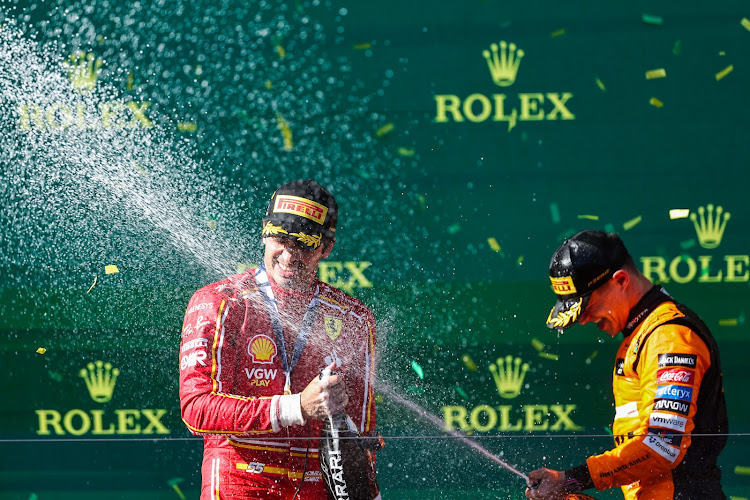 Ferrari's Carlos Sainz of Spain (L) and Mclaren's Lando Norris of Britain celebrate with champagne on the podium