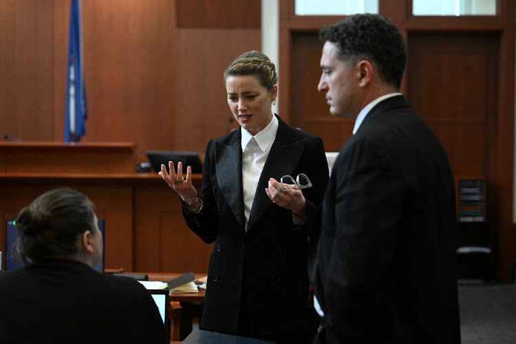 Amber Heard speaks to her lawyer in the Fairfax County circuit court during the defamation case against her by Johnny Depp, her ex-husband.