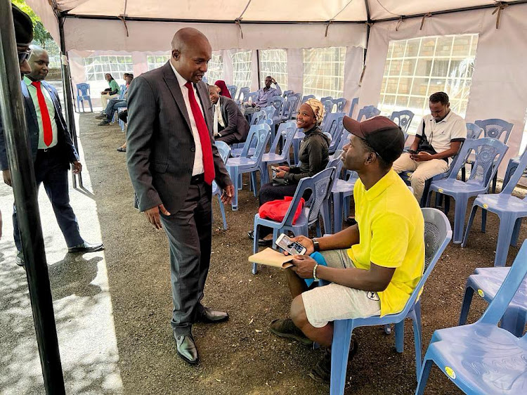 Interior CS Kithure Kindiki interacting with a Kenyan at Nyayo House when he made an impromptu visit on October 30, 2023.