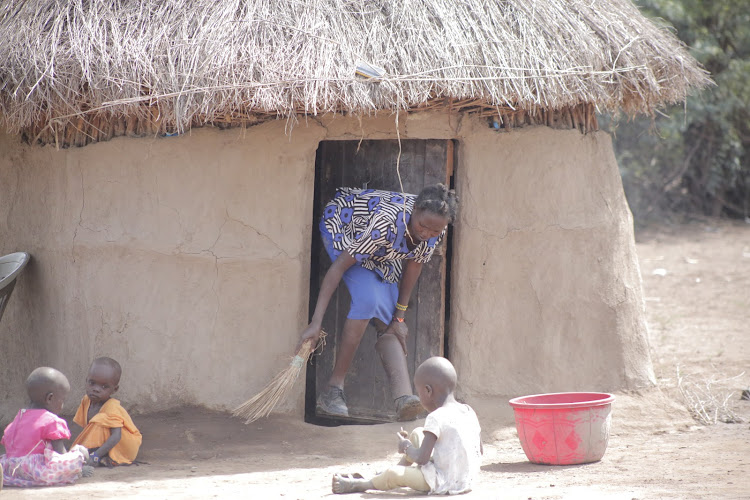 Crocodile attack survivor Winnie Keben holds her artificial left leg while sweeping her house near Lake Baringo on September 18