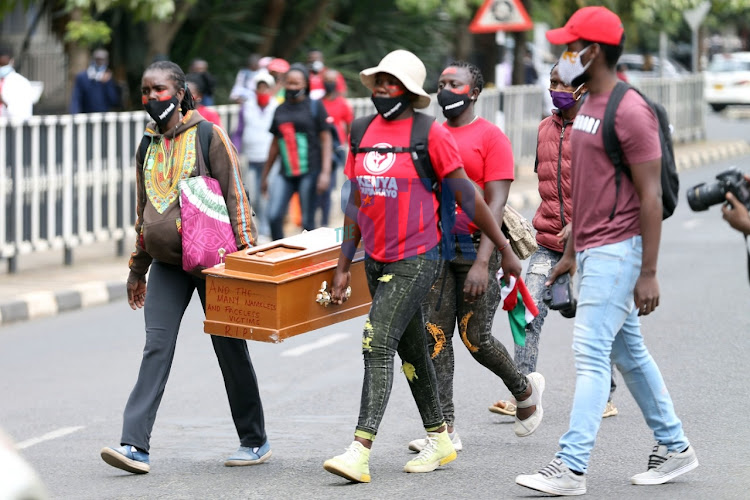 Youths carrying a coffin demonstrate outside Parliament on June 9, 2020.